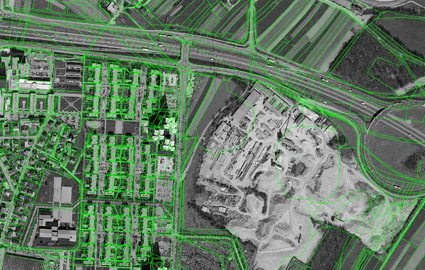Črno-beli ortofoto 1997–2000 pri Stožicah: na mestu današnjega športnega parka so industrijski objekti in odprte izkopne površine; čez je narisan sedanji kataster.